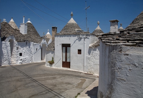 Immagine con tetti, trulli, porta, bianco, comignoli, case, alberobello