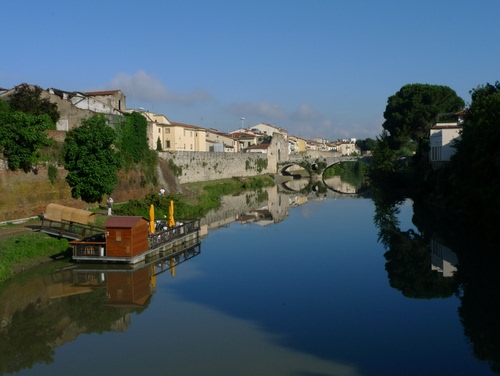 Immagine con alberi, fiume, ponte, acqua, riflesso, verde, cielo, nuvole, case, panorama, riflessi, paese, chiatta, barcone
