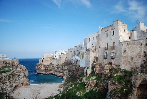 Immagine con mare, spiaggia, cielo, rocce, case, acqua, azzurro, finestre, scogli, insenatura, blu, scogliera, erba, scorcio, nuvole, roccia, paese, panorama, puglia