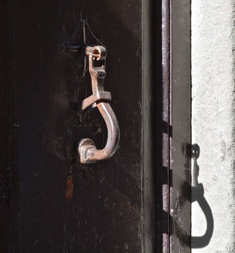 Immagine con ombra, porta, batacchio, muro, portone, ferro, metallo, maniglia, legno