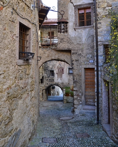 Immagine con vicolo, finestre, archi, lampione, porta, case, pietre, porte, palazzi