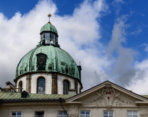 Immagine con cupola, nuvole, finestre, cielo, tetto, verde, stemma, chiesa, abbaini