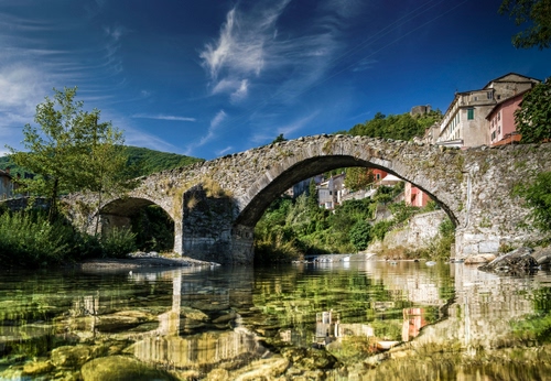Immagine con ponte, acqua, fiume, nuvole, cielo, riflessi, case, riflesso, archi, alberi, pietre, borgo, arcate, verde, albero
