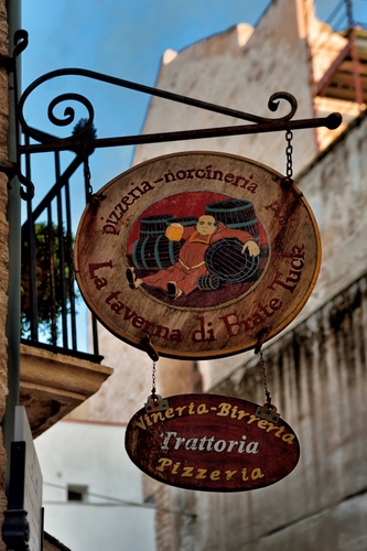 Immagine con insegna, pizzeria, trattoria, balcone, ringhiera, ferro, ovale, insegne, frate, botti, cielo, palazzi