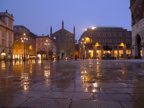 Immagine con chiesa, piazza, luci, pioggia, riflessi, lampioni, portici, cielo, finestre, palazzi, notturno, notte, bagnato, archi, monumento, riflesso