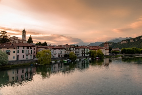 Immagine con riflesso, fiume, campanile, acqua, case, tramonto, borgo, nuvole, paese, lago, alba, cielo, alberi