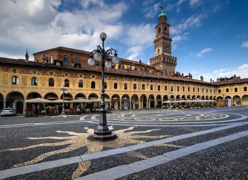 Immagine con piazza, lampione, torre, nuvole, portici, archi, palazzi
