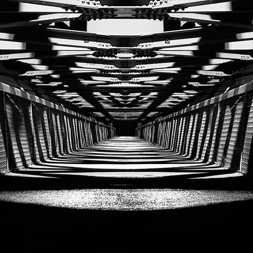 Immagine con ombre, bianconero, ponte, prospettiva, geometrie, travi, ferro, metallo, nero, linee, luci, architettura, tunnel