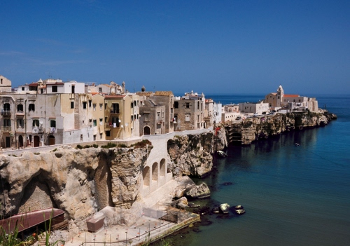 Immagine con mare, acqua, chiesa, case, cielo, finestre, scogli, blu, paese, azzurro, borgo, panorama, promontorio, bianco, edifici, archi, costa, scogliera