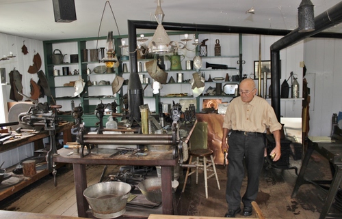 Immagine con artigiano, uomo, attrezzi, bottega, lavoro, anziano, sgabello, artigianato, tavolo, antichità