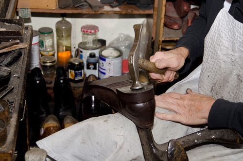 Immagine con martello, mani, scarpa, calzolaio, artigiano, scarpe, barattoli, grembiule, ciabattino