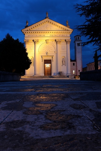 Immagine con campanile, colonne, chiesa, alberi, notturno, notte, statue, luci, blu, facciata, portone, porta, capitelli, luce