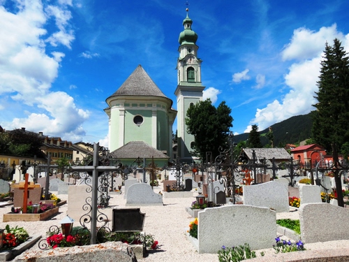 Immagine con cimitero, croci, chiesa, campanile, tombe, lapidi, nuvole