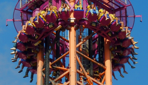 Immagine con giostra, persone, divertimento, cielo, gambe, colori, azzurro, attrazione, arancione, rosa, alto, parco, traliccio, ragazzi, giallo, sedili