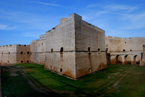 Immagine con castello, mura, ponte, fossato, merli, archi, prato, verde, cielo, finestre, torre