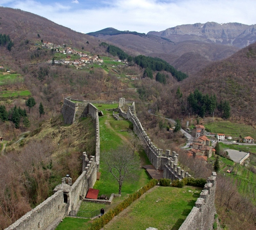 Immagine con merli, mura, alberi, montagne, panorama, case, verde, fortificazione, fortezza, montagna, erba, muraglia, cielo, paese, bastioni, bosco