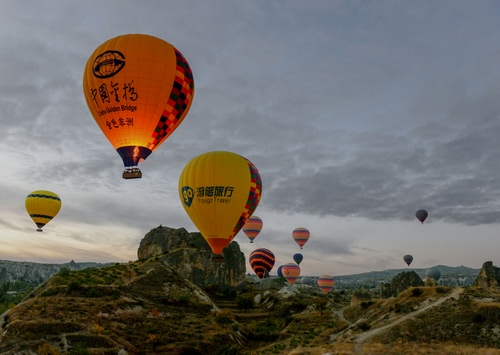 Immagine con mongolfiere, giallo, cielo, nuvole, arancione, palloni, rocce, paesaggio, colori, montagne, strade, verde, volo, mongolfiera