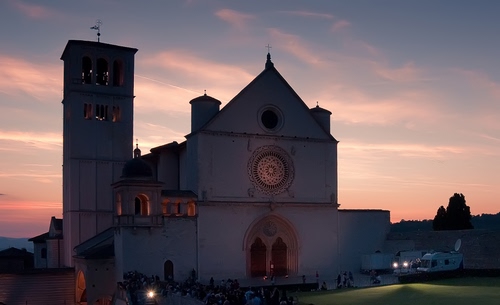 Immagine con chiesa, campanile, rosone, luci, tramonto, nuvole, cielo, assisi, basilica, croce, verde, francesco, alba, rosa
