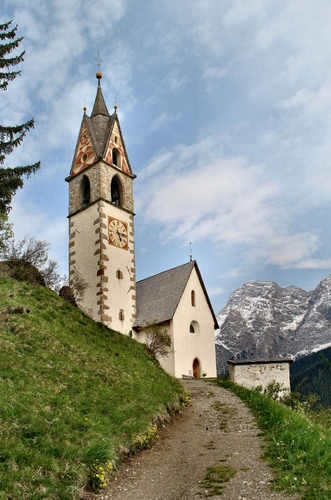 Immagine con campanile, chiesa, montagna, erba, orologio, strada, sentiero, nuvole, montagne, prato, cielo, albero, chiesetta, croce, croci, verde, neve