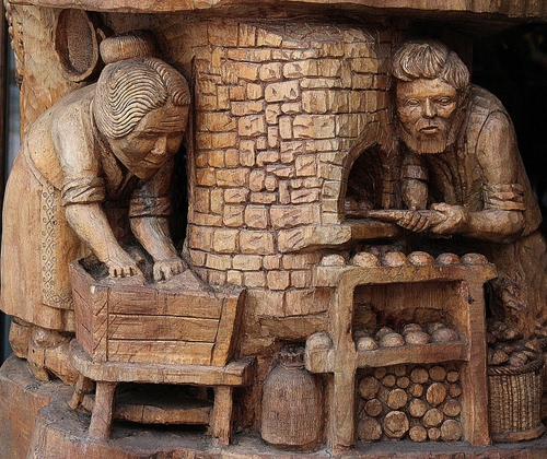 Immagine con legno, forno, scultura, pane, donna, uomo, marrone, sculture, fornaio, statue, due
