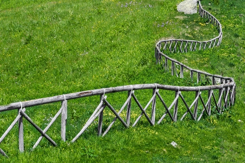 Immagine con staccionata, legno, verde, erba, prato, curve, triangoli, curva, campo