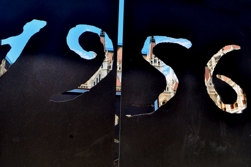 Immagine con nero, numeri, anno, scorcio, azzurro, città, cielo, numero, millenovecentocinquantasei, colori, palazzi, porta, finestra, scritta