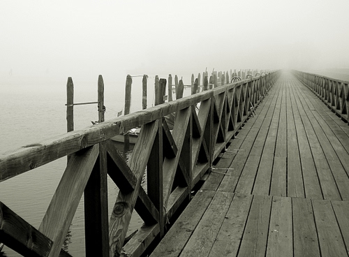 Immagine con legno, nebbia, ponte, acqua, pali, assi, parapetto, pontile, foschia, staccionata, ics, prospettiva, tavole, barche, bianconero